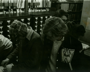 Librarians working at a large bank of card catalogs.