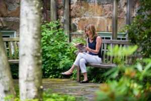 A library patron reading outside on the Hills Branch patio.