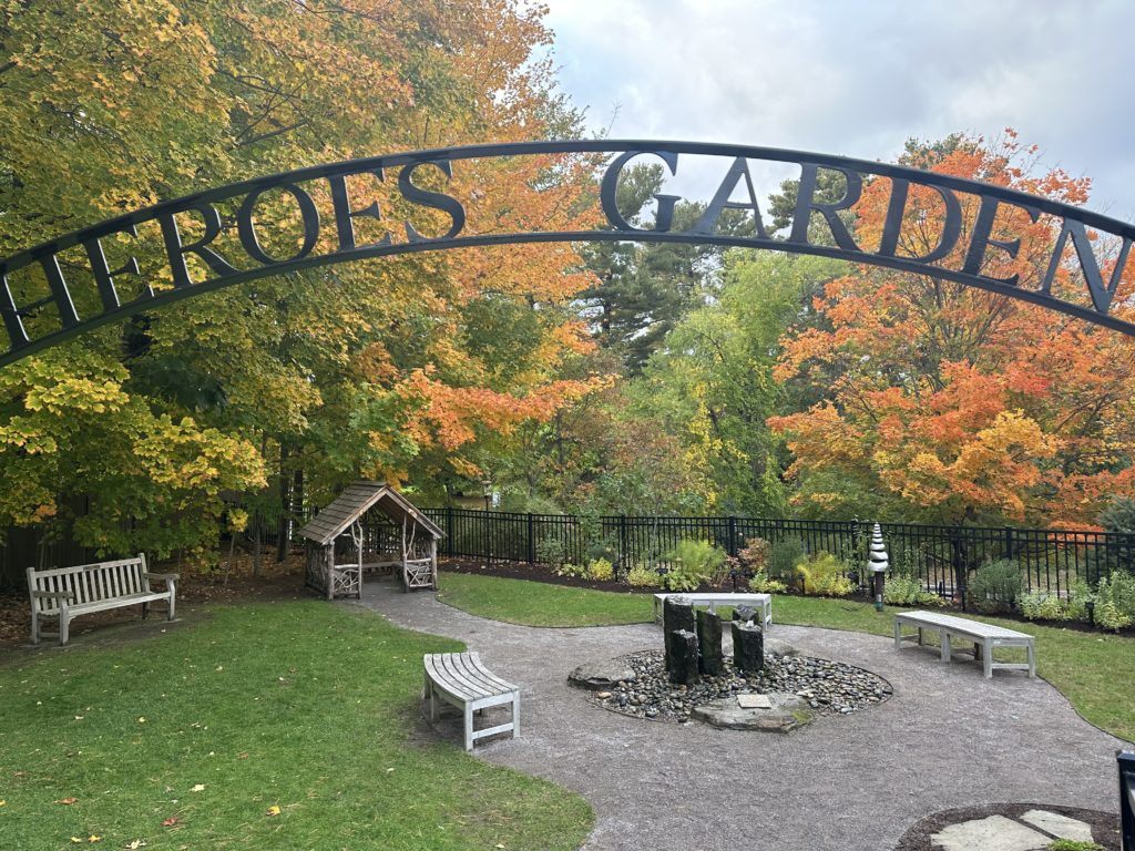 The Heroes Garden has a small fountain, multiple stone benches, and room enough for children to play on the grass.