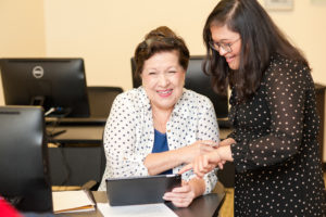 A librarian helping a patron with technology in our computer lab.