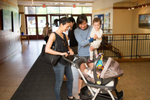 Two patrons in the back lobby with their young children.