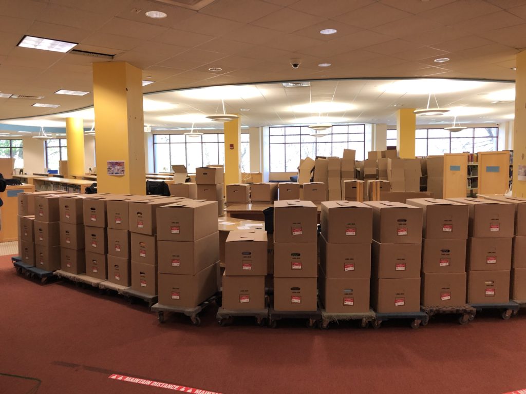 The old Children's room with a 3-tall wall of boxes stretching the entire shot. There are more (likely empty) boxes behind those, and even more half-made boxes toward the back.