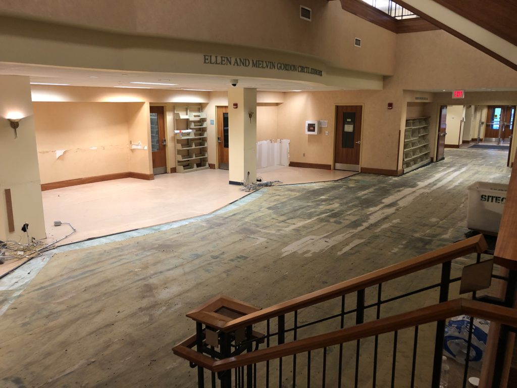 The space that would become the Welcome Area before the linoleum tiles covering the staff part of the floor were removed. The desk is no longer there, but its footprint can be seen in the shape of the linoleum floor.