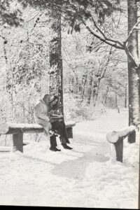 Wilbury Crockett and Linda Barnes sat next to each other, seemingly discussing some piece of writing on a snowy path.