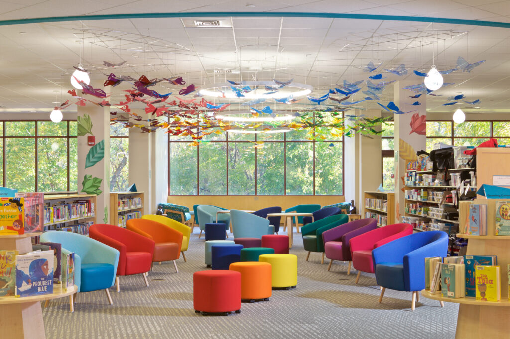 The Children's Room finished with bright colored chairs organized under the installation of origami butterflies shaped from clear acrylic in the colors of the rainbow.
