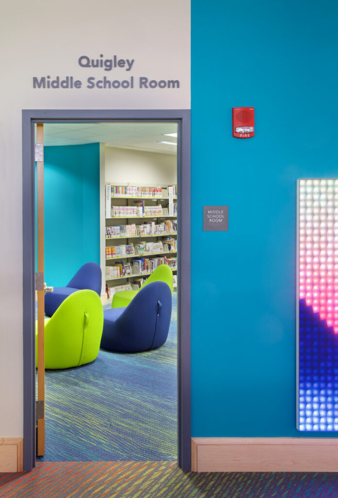 The open doorway to the newly renovated Middle School Room, showing four colorful gaming chairs and a sliver of the LUMES wall.