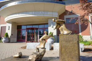 Reach for Knowledge sculpture in front of the Library's back entry doors.